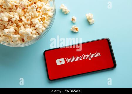 Nikolaev, Ucraina - 20 novembre 2021: Popcorn e logo YouTube su smartphone su sfondo blu. Vista dall'alto Foto Stock