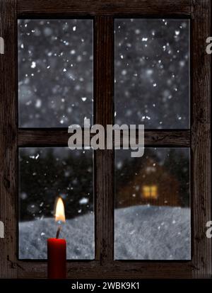 Vista da una vecchia finestra di legno con una candela in inverno Foto Stock