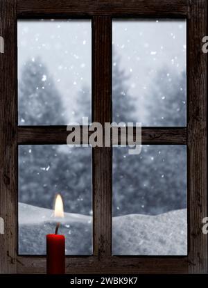 Vista da una vecchia finestra di legno con una candela in inverno Foto Stock