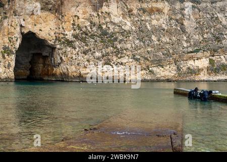 Dwejra, Malta - 19 dicembre 2023: Due subacquei che si preparano a fare immersioni nel Mare interno e nei siti di immersione Blue Hole sull'isola di Gozo a Malta Foto Stock