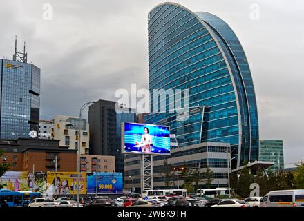 Grande schermo che mostra le notizie serali sulla televisione mongola in Piazza Sukhbaatar di fronte al Blue Sky Hotel, Ulan Bator, Mongolia Foto Stock