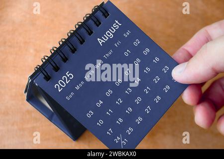 Agosto 2025 calendario bianco e nero su scrivania di legno. Concetto di calendario e nuovo mese. Foto Stock