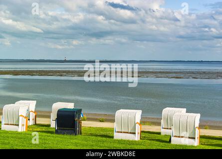 Sedie a sdraio sulla spiaggia sud di Wilhelmshaven con vista sul mare durante l'alta marea Foto Stock