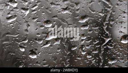 Gocciolamento di pioggia sul parabrezza della vettura, Foto Stock