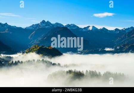 Chiesa del castello di St. Michael vicino a Fischen sopra la nebbia di fronte alle Alpi innevate autunnali di Allgäu. Baviera, Germania, Europa Foto Stock