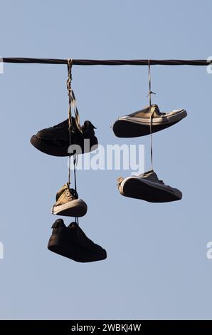 sneakers appese a una linea elettrica Foto Stock