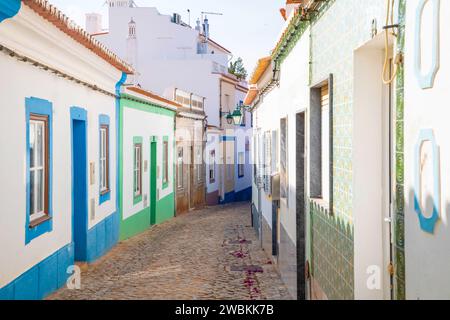 Ferragudo, Algarve, Portogallo.26 settembre 2020. tradizionali case bianche con tetti piastrellati su stradine strette decorate con fiori di bouganville Foto Stock