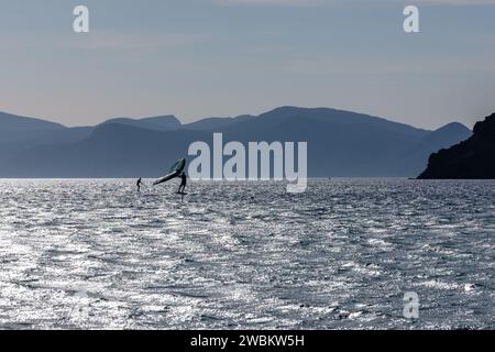 Vista di un turista che si diverte a fare surf in aliscafo presso la spiaggia di Mylopotas a iOS in Grecia Foto Stock