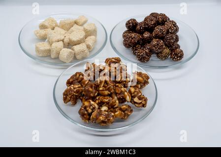 Tre piatti pieni di sesamo Ladoo, Til ko Laddu, Jaggery Peanuts Laddoo per Maghe Sankranti e Makar Sankranti Festival in Nepal e India Foto Stock