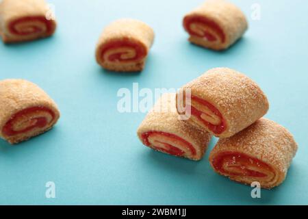 Biscotti fatti in casa, mini panini con marmellata di albicocche su sfondo blu. Foto Stock