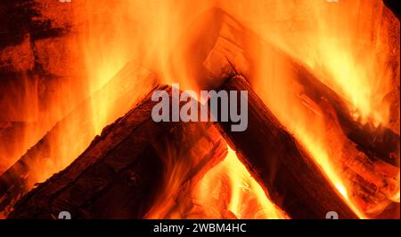 Caminetto a legna. Il fuoco si tiene caldo. Cresta di fiamma sul legno bruciato nel caminetto. Messa a fuoco morbida. Messa a fuoco sfocata Foto Stock