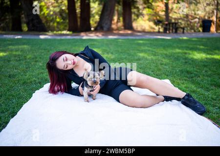 Donna cinese che gioca con il suo cane Yorkshire Terrier nel parco Foto Stock