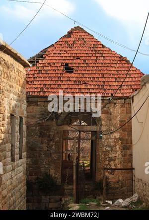Una casa tradizionale nel villaggio libanese con un tetto e una porta rotti. Foto Stock