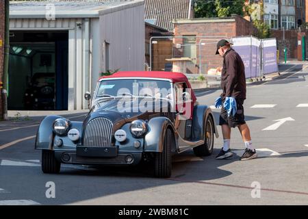 vista frontale della morgan decappottabile grigio nero più 8 auto sportive presso la fabbrica di auto morgan di malvern worcestershire regno unito con un lavoratore Foto Stock