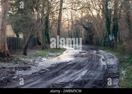 Eton, Windsor, Regno Unito. 11 gennaio 2024. Ghiaccio letale su una strada di campagna a Eton, Windsor, Berkshire, dopo un'inondazione dal Tamigi. Un allarme alluvione rimane in atto per il fiume Tamigi a Eton, Windsor, Berkshire. Fortunatamente i livelli delle acque alluvionali stanno cominciando a diminuire. Credito: Maureen McLean/Alamy Live News Foto Stock