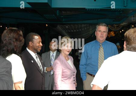 KENNEDY SPACE CENTER, FLA. - Al centro Apollo SaturnV del Kennedy Space Center della NASA, la First Lady Laura Bush e il governatore della Florida Jeb Bush (a destra) salutano gli altri ospiti che partecipano al lancio dello Space Shuttle Discovery sulla missione STS-114 di ritorno al volo, previsto il decollo alle 10 39 EDT dalla piattaforma di lancio 39B con un equipaggio di sette persone. A sinistra c'è il vice direttore del KSC Woodrow Whitlow Jr. La signora Bush è solo la terza First Lady ad assistere a un lancio dello Space Shuttle al KSC. In questa missione alla stazione spaziale Internazionale l'equipaggio effettuerà ispezioni in orbita per la prima volta di tutti i C rinforzati Foto Stock