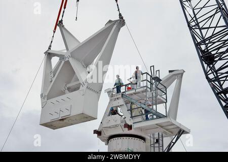 KENNEDY SPACE CENTER, FLA. - In un sito radar a North Merritt Island, Flag., il secondo contrappeso viene sollevato per l'installazione sulla struttura di supporto (a destra) di un'antenna radar in banda C da 50 piedi. Il radar verrà utilizzato per le missioni dello Shuttle per tracciare i lanci e osservare i possibili detriti provenienti dallo Shuttle. Verrà utilizzato per la prima volta su STS-114. La finestra di lancio per la prima missione di ritorno al volo va dal 13 al 31 luglio. Foto Stock