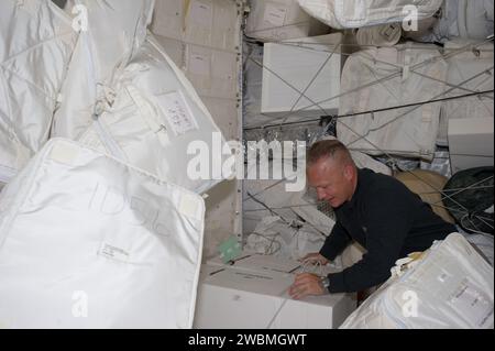 S135-e-007441 (11 luglio 2011) --- l'astronauta NASA Doug Hurley, pilota STS-135, si muove intorno a provviste e attrezzature nel Leonardo Permanent Multipurpose Module (PMM) durante il quarto giorno di volo per l'equipaggio di quattro persone di Atlantis. Questo modulo è un componente che si è Unito al complesso della stazione spaziale Internazionale dopo essere stato trasportato nello spazio a bordo dello Space Shuttle Discovery sulla STS-133. Foto Stock