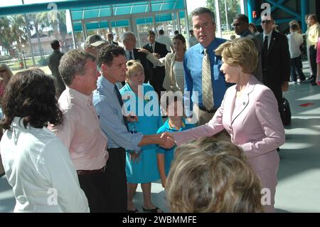 KENNEDY SPACE CENTER, FLA. - Al Centro Apollo Saturn V del NASA Kennedy Space Center, la First Lady Laura Bush (a destra) saluta il deputato della Florida Dave Weldon (stringendo la mano) e il deputato Tom Feeney. Stanno assistendo allo storico lancio dello Space Shuttle Discovery durante la missione STS-114 di ritorno al volo, prevista per il decollo alle 10 39 EDT dalla piattaforma di lancio 39B con un equipaggio di sette persone. La signora Bush è solo la terza First Lady ad assistere al lancio dello Space Shuttle al KSC. Dietro la signora Bush c'e' il governatore della Florida Jeb Bush. In questa missione alla stazione spaziale Internazionale l'equipaggio effettuerà ispezioni in orbita Foto Stock