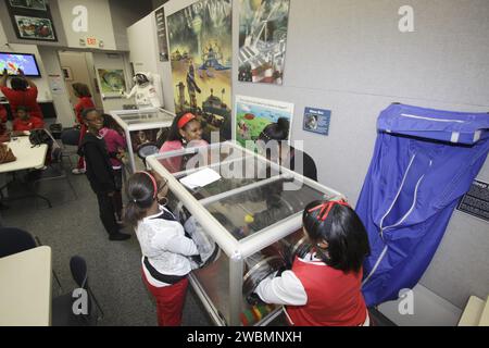 Gli studenti delle scuole medie e superiori delle contee della Florida partecipano a una dimostrazione scientifica presso il Kennedy Space Center della NASA. Gli studenti esercitano a maneggiare i materiali in un cassetto portaoggetti. Il programma, Delta Academy e Delta GEMS, promuove l'educazione STEM, l'eccellenza accademica e la consapevolezza della carriera attraverso il tutoraggio e le presentazioni di donne professionisti che lavorano alla NASA. Foto Stock