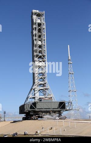 CAPE CANAVERAL, Ban. – La pista di lancio del Launch Pad 39B al Kennedy Space Center della NASA in Florida è spruzzata d'acqua per ridurre la polvere che volerà mentre il trasportatore cingolato rotola. Il cingolato sta restituendo il lanciatore mobile, o ML, al sito del parco vicino all'edificio di assemblaggio dei veicoli. I dati sul ML raccolti dai test di ingegneria strutturale e funzionale durante la sua permanenza di due settimane sul pad saranno utilizzati nelle fasi successive della costruzione. La struttura ML alta 355 piedi, che ha richiesto circa due anni per la costruzione, sarà modificata dal 21st Century Ground Systems Program della NASA Foto Stock