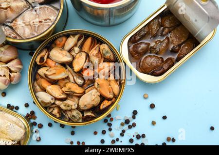 Lattine aperte con cozze su sfondo blu Foto Stock