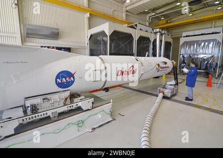 Un tecnico ispeziona il razzo Pegasus XL con il telescopio a raggi X NuSTAR della NASA all'interno dell'hangar di Orbital presso la Vandenberg Air Force base prima di essere spostato su un trasportatore alla pista per l'attacco a un aereo L-1011 per il lancio per studiare buchi neri e raggi cosmici. Foto Stock