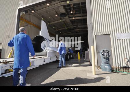 I tecnici della Vandenberg Air Force base monitorano il razzo Pegasus XL e il telescopio NuSTAR in quanto è posizionato sotto un trasportatore all'interno dell'hangar di Orbital prima di essere spostato sulla pista per il lancio per studiare buchi neri, resti di supernova, raggi cosmici e fisica stellare. Foto Stock
