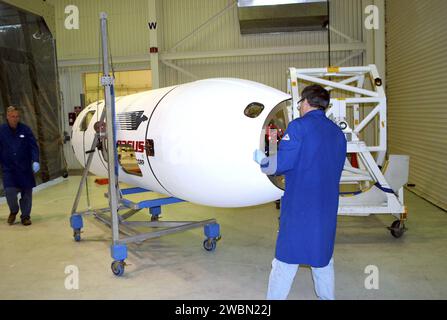 Un tecnico della Vandenberg Air Force base, California, sposta una sezione della carenatura del veicolo spaziale NuSTAR verso una camera bianca. La carenatura proteggerà il telescopio durante la salita su un razzo Pegasus XL. Dopo l'elaborazione, il razzo e la navicella spaziale saranno portati all'atollo di Kwajalein per il lancio. NuStar studierà i buchi neri, i resti di supernova, i raggi cosmici e la fisica delle stelle collassate. Foto Stock