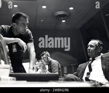 CAPE CANAVERAL, Ban. All'interno del Mercury Mission Control, l'astronauta Deke Slayton Left discute un punto con Christopher Kraft, direttore di volo della Mercury, durante i preparativi per il lancio dell'astronauta Gordon Cooper Faith 7, avvenuto il 15 maggio 1963. Il Mercury Mission Control Center in Florida ha svolto un ruolo chiave nel primo programma di volo spaziale degli Stati Uniti. Situata presso Cape Canaveral Air Force Station, la parte originale dell'edificio fu costruita tra il 1956 e il 1958, con aggiunte nel 1959 e nel 1963. La struttura è stata ufficialmente trasferita alla NASA il 26 dicembre 1963, e ha servito come Miss Foto Stock