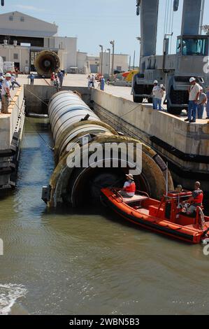 CAPE CANAVERAL, Ban. -- membri dell'equipaggio in uno skiff della Liberty Star, una delle navi di recupero con razzo solido della NASA, inaugurano un booster navetta passato alla Hangar AF alla Cape Canaveral Air Force Station in Florida. Il booster è stato utilizzato durante il lancio dello Space Shuttle Discovery STS-133 dal Launch Pad 39A del NASA Kennedy Space Center il 24 febbraio. I due involucri solidi del razzo e l'hardware di volo associato vengono recuperati nell'Oceano Atlantico dopo ogni lancio da parte di Freedom Star e Liberty Star. I booster colpiscono l'Atlantico circa sette minuti dopo il decollo e le navi di recupero Foto Stock