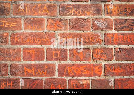 Nomi graffiati su un Brick Wall a Bedford Foto Stock