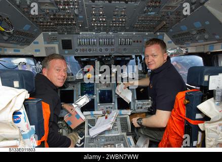 S133-e-011803 (7 marzo 2011) --- gli astronauti NASA Steve Lindsey (a sinistra), comandante STS-133; ed Eric Boe, pilota, sono raffigurati nelle rispettive stazioni sul ponte di volo anteriore dello Space Shuttle Discovery durante le attività del giorno 12 del volo. Foto Stock