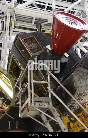 CAPE CANAVERAL, Ban. Nell'Orbiter Processing Facility-2 al Kennedy Space Center della NASA in Florida, i lavoratori usano una gru per rimuovere il sistema di manovra orbitale destro della Discovery, o OMS, POD. Verrà poi trasportato alla struttura di manutenzione Hypergol. La rimozione fa parte del processo di transizione e ritiro del Discovery. Il lavoro svolto su Discovery dovrebbe aiutare i progettisti di razzi a costruire veicoli spaziali di nuova generazione e preparare lo shuttle per il futuro pubblico. Foto Stock