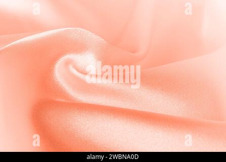 Colore dell'anno 2024 Peach Fuzz 13-1023. Colore pesco fuzz texture di seta, sfondo. Colore dell'anno 2024 per design, mockup testuale, carte, lusso co Foto Stock
