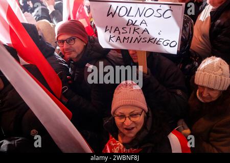 Varsavia, Polonia, 11 gennaio 2024. Folle di persone, con bandiere nazionali polacche e uno striscione che recita "libertà per Wasik e Kaminski”, guidato dalla legge e dalla giustizia (Prawo i Sprawiedliwość - PIS) i leader dei partiti politici protestano di fronte all'edificio del Parlamento polacco contro i cambiamenti nei media pubblici in Polonia e nella protezione della democrazia - dicono i politici del PIS. Il partito legge e giustizia governò in Polonia per 8 anni fino a quando non perse le ultime elezioni nell'ottobre 2023. Il partito diventa ora una forza di opposizione di destra contro una coalizione di governo più centrista e liberale, dove la principale politica Foto Stock