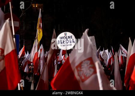 Varsavia, Polonia, 11 gennaio 2024. Folle di persone, con bandiere nazionali polacche e uno striscione che recita "mezzi di comunicazione liberi”, guidati dalla legge e dalla giustizia (Prawo i Sprawiedliwość - PIS), i leader dei partiti politici protestano di fronte all'edificio del Parlamento polacco contro i cambiamenti nei media pubblici in Polonia e a tutela della democrazia - dicono i politici del PIS. Il partito legge e giustizia governò in Polonia per 8 anni fino a quando non perse le ultime elezioni nell'ottobre 2023. Il partito diventa ora una forza di opposizione di destra contro una coalizione di governo più centrista e liberale, dove la forza politica principale è Civic Coali Foto Stock