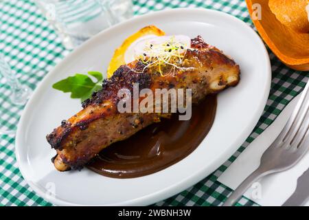 Costolette di maiale alla griglia in salsa di cioccolato con patate al forno Foto Stock