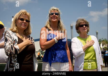 Patty Carpenter, moglie dell'astronauta NASA Mercury Scott Carpenter, Left, Daughters of NASA astronauta Alan Shepard, Laura Shepard Churchley e Alice Wackermann, Right, cantate l'inno nazionale durante una cerimonia di inaugurazione di due francobolli USPS che commemorano e celebrano i 50 anni di US Spaceflight e il programma MESSENGER durante un evento, mercoledì 4 maggio 2011 presso il NASA Kennedy Space Center a Cape Canaveral, Flag. Un francobollo commemora il progetto Mercury della NASA, il primo programma di volo spaziale con equipaggio americano, e lo storico volo dell'astronauta Alan Shepard il 5 maggio 1961, a bordo della navicella spaziale FR Foto Stock