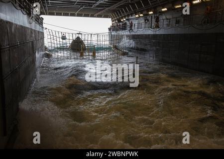 I membri della squadra di recupero guardano mentre la versione di prova del modulo Orion Crew viene guidata nel ponte sommerso della USS San Diego durante il Recovery test 5 in corso nell'Oceano Pacifico al largo della costa della California il 30 ottobre 2016. Il Ground Systems Development and Operations Program della NASA e la Marina degli Stati Uniti stanno conducendo una serie di test utilizzando il ponte della nave, il modulo di test, varie moto d'acqua e attrezzature per prepararsi al recupero di Orion al suo ritorno dalle missioni nello spazio profondo. I test consentiranno al team di dimostrare e valutare i processi, le procedure, l'hardware e. Foto Stock