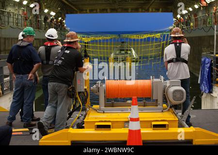 I membri della squadra per le operazioni con verricello guardano come una versione di prova del modulo dell'equipaggio Orion è fissata nel ponte sommerso della USS San Diego per l'inizio del test 5 di recupero in corso nell'Oceano Pacifico al largo della costa della California. Il Ground Systems Development and Operations Program della NASA e la US Navy stanno conducendo una serie di test per prepararsi al recupero di Orion al suo ritorno dalle missioni spaziali profonde. Il test consentirà al team di dimostrare e valutare i processi, le procedure, l'hardware e il personale di ripristino in acque aperte. Parte delle immagini batch trasferite da Flickr. Foto Stock