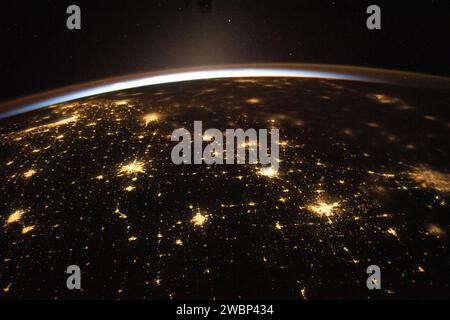 L'alba illumina l'atmosfera terrestre in una fotografia della stazione spaziale Internazionale che orbita a 260 miglia sopra gli Stati Uniti centrali, mostrando Chicago delimitata dal lago Michigan e dall'area metropolitana di Dallas/Fort Worth attraverso le nuvole il 10 novembre 2023. Foto Stock