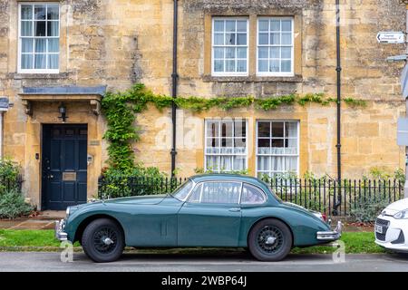 Auto sportiva Jaguar XK classica parcheggiata all'esterno di una proprietà in pietra del cotswold nella città mercato di Chipping Campden, Inghilterra, Regno Unito, 2023 Foto Stock