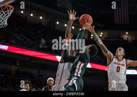 I Washington State Cougars guardano Myles Rice (2) tentano un colpo contro l'attaccante dei troiani dell'USC Kijani Wright (33) e la guardia Kobe Johnson (0) durante una NCAA Foto Stock