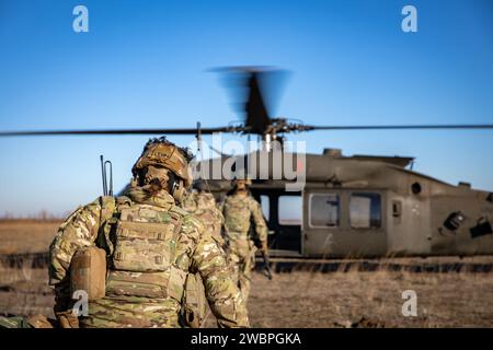 Soldati d'artiglieria della Bravo Battery 'Bone Crusher', 3rd Battalion, 320th Field Artillery Regiment, 3rd Brigade Combat Team, 101st Airborne Division, attaccati alla “Task Force 82”, conducono un assalto aereo con il 3rd Attack Helicopter Battalion, 1st Aviation Regiment, 1st Combat Aviation Brigade, 1st Infantry Division, presso Mihail Kogalniceanu Air base, Romania, 11 gennaio 2024, per aumentare la prontezza e la competenza nelle operazioni di assalto aereo. (Foto dell'esercito degli Stati Uniti di PFC. Aiden o'Marra) Foto Stock