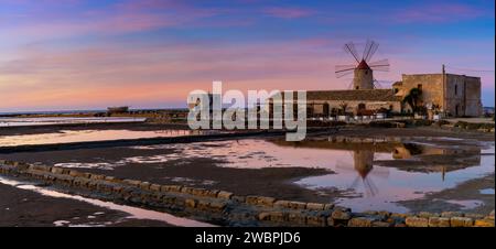 Paceco, Italia - 3 gennaio 2024: Vista del mulino a vento e del museo delle saline di Paceco al tramonto Foto Stock