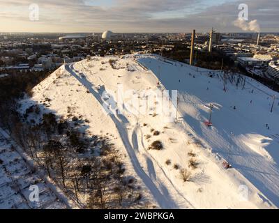 Vista invernale delle piste da sci di Stoccolma ad Hammarbybacken, vicino al quartiere di Hammarby. Ericsson Globen sullo sfondo. Parzialmente nuvoloso e luminoso. Foto Stock