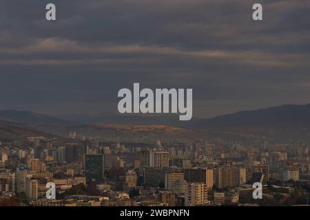 Una vista panoramica di Tbilisi circondata da maestose montagne in lontananza all'alba in Georgia Foto Stock