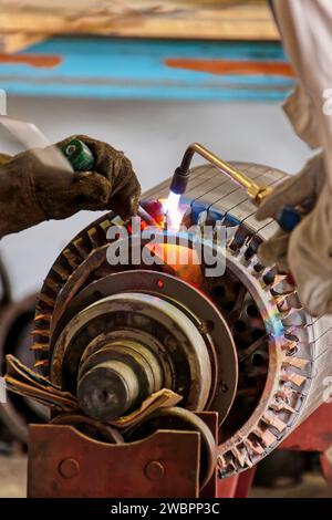 riavvolgimento del motore elettrico, tagliando il vecchio avvolgimento con una torcia Foto Stock