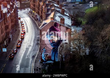 Uno dei murales più noti di Glasgow, dell'artista di strada Smug, che ritrae una moderna St Mungo e fa riferimento alla storia dell'uccello che non ha mai volato, sul lato di una proprietà su High Street, Glasgow. Il 13 gennaio è la festa di San Mungo, santo patrono e fondatore della città di Glasgow. Data immagine: Giovedì 11 gennaio 2024. Foto Stock